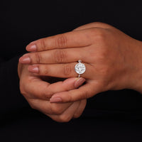 Hand wearing a diamond ring on a black background