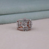 Rose gold and silver ring with floral design on a light gray surface