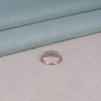 Rose gold ring with gemstones on a light gray surface, Unique Moissanite Bridal Ring, Minimalist Moissanite Ring