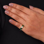 Hand wearing a ring with a green gemstone on a black background, Round & Green Emerald Baguette CZ Ring, Bezel and Channel Setting Statement Jewelry