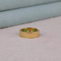 Gold ring with green inlay on a light gray surface, Bezel & Channel Set Emerald Baguette CZ Stone Ring, Modern Statement Jewelry
