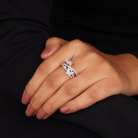 Hand wearing a diamond ring on a black background