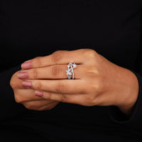 Hand wearing a silver ring with a black background