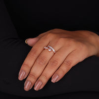 Close-up of a hand wearing a diamond ring on a black background, Bypass Open Gap Ring – Pear & Baguette Cut Moissanite Channel Set Ring