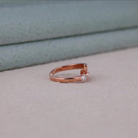 Rose gold ring with a small diamond on a light gray surface, Unique Bypass Moissanite Ring – Pear & Baguette Channel Set Open Design