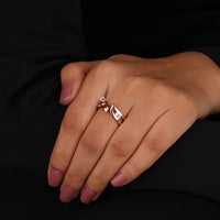 Hand wearing a silver ring with a unique design on a black background