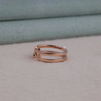 Rose gold ring with small diamonds on a neutral background