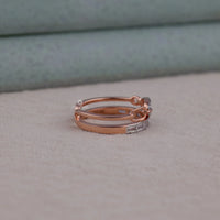 Stack of rose gold rings on a neutral background