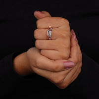 Close-up of a hand wearing two rings on a black background