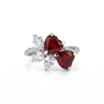 Heart cut Cubic Zirconia floral cluster ring featuring deep red center stones, clear marquise and pear accent stones, pavé band, elegant statement design.