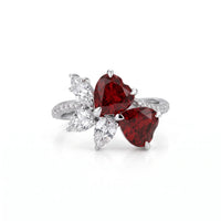 Heart cut Cubic Zirconia floral cluster ring featuring deep red center stones, clear marquise and pear accent stones, pavé band, elegant statement design.