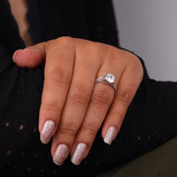 Hand wearing a diamond ring with glittery nail polish on a dark background, Vintage Inspired Art Deco Moissanite Engagement Ring, Round Solitaire with Milgrain Detail