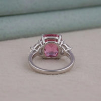 Silver ring with a pink gemstone on a light gray background