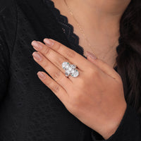 Hand wearing a diamond ring with a black lace background, Green Triangle & Round CZ Art Deco Ring – Vintage Lozenge Milgrain Dinner Ring