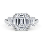 Diamond ring with emerald-cut stones on a white background