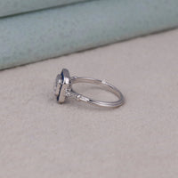 Silver ring with a large central gemstone and smaller stones on a light gray surface, sapphire art deco promise ring, unique sapphire engagement ring for women, sapphire geometric style wedding ring