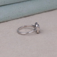 Silver ring with a diamond on a light gray surface, luxury sapphire and diamond wedding ring, asscher cut gemstone art deco ring