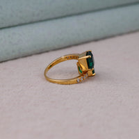 Gold ring with a green gemstone on a light gray surface, Green Asscher Cut CZ Stone Bypass Toi Et Moi Engagement Wedding Ring