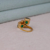 Gold ring with green gemstones on a light pink surface, Green Asscher Cut CZ Stone Bypass Toi Et Moi Engagement Wedding Ring, Asscher Cut CZ Engagement Ring, Toi Et Moi CZ Wedding Ring