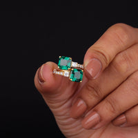 Green gemstone earrings held between fingers against a black background, Green Asscher Cut CZ Anniversary Ring, Stylish Toi Et Moi Proposal Ring, Eco Friendly CZ Bridal Jewelry