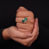 Hand wearing a ring with emerald stones on a black background, Fashionable Toi Et Moi Bridal Ring, Cubic Zirconia Toi Et Moi Ring, Chic CZ Two Stone Wedding Ring