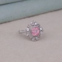 Pink gemstone ring with silver and diamond accents on a light gray surface, party wear pink cushion halo stone jewelry, pink cushion halo cz cocktail ring for her
