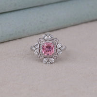 Ring with a pink gemstone and diamond accents on a light background, pink cushion stone halo cocktail jewelry, elegant pink stone halo party ring