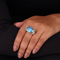 Hand wearing a ring with a blue gemstone on a black background, Aqua-Man Poseidon Mascot Cocktail Ring, Ocean Inspired Statement Jewelry