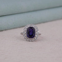 Ring with purple gemstone and diamond halo on a light background, Sapphire Cushion Cut Halo Ring | Vintage CZ Engagement & Cocktail Jewelry