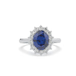 Ring with a blue gemstone and diamond accents on a white background