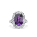 Ring with a purple gemstone and diamond-studded band on a white background
