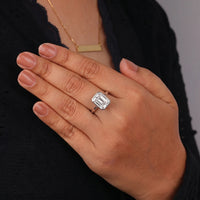 Hand wearing a diamond ring with a blurred background