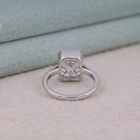 Silver ring with a square-cut gemstone on a textured surface