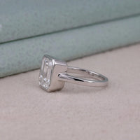 Silver ring with a diamond on a light gray surface