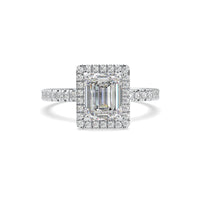 Diamond ring with emerald-cut center stone on a white background