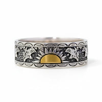 Silver ring with black and white pattern and gold accent on a white background
