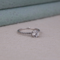 Silver ring with a diamond on a light gray surface, Conflict Free Moissanite Ring, Sustainable Round Engagement Ring, Bridal Jewelry with Hidden Halo.