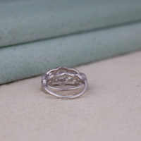 Silver ring with a clear gemstone on a textured surface