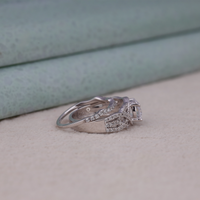 Two diamond rings stacked on a light wooden surface with a soft blue background