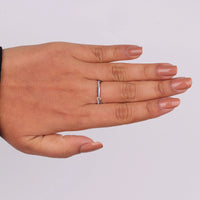 Hand wearing a silver ring on a plain background, Modern Twisted Moissanite Wedding Band, Minimalist Half Eternity Stacking Ring, Sustainable Moissanite Bridal Jewelry