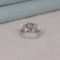 Silver ring with gemstones on a light gray surface, Round cut CZ three stone antique art deco ring, vintage style CZ engagement ring