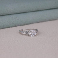 Silver ring with a large diamond on a soft fabric background