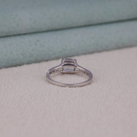 Silver ring with a diamond on a light gray surface