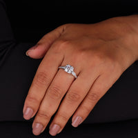 Hand wearing a diamond ring on a black background