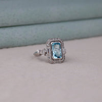 Silver ring with a blue gemstone on a light gray background