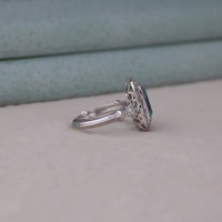Silver ring with a blue gemstone on a neutral background