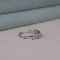 Silver ring with gemstones on a textured surface, Eco Friendly Moissanite Ring, Timeless Baguette Half Eternity Band, Moissanite Fashion Ring, Symbolic Anniversary Eternity Ring