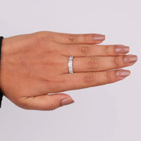 Hand wearing a silver ring on a plain background, Sustainable Moissanite Jewelry, Affordable Moissanite Eternity Ring, Unique Moissanite Stacking Band