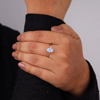 Hand wearing a ring with a blue gemstone against a neutral background, Minimalist Five Stone Promise Ring For Women, Elegant Moonstone And White CZ Wedding Jewelry
