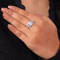 Hand wearing a diamond ring with a blurred background